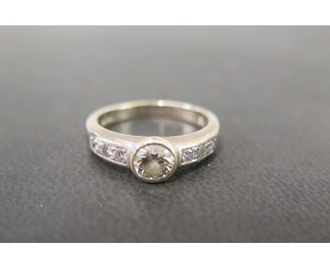 An 18ct gold diamond ring - The brilliant-cut diamond to the similarly-cut diamond shoulders and plain band - Principal diamo