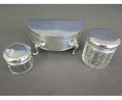 A silver trinket box and three silver top bottles 