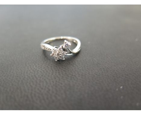 A diamond dress ring - The diamond floral cluster and leaf to the asymmetric shoulders and plain band - Stamped 750 - Ring si