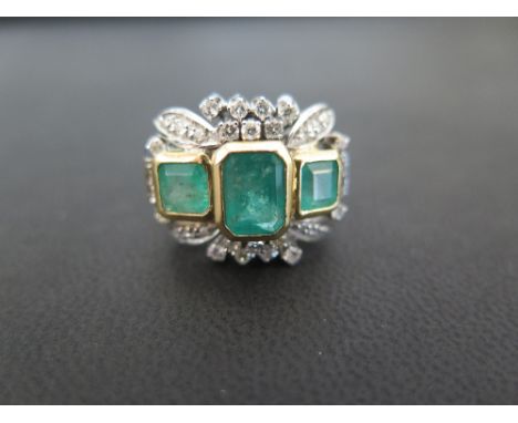 An emerald and diamond cluster ring - The rectangular and square-shape emeralds within a brilliant-cut diamond surround - Eme