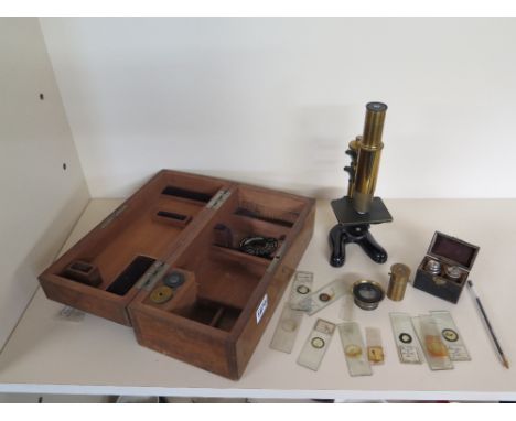 A lacquered brass students field microscope with a selection of slides and a pair of Leitz box objectives