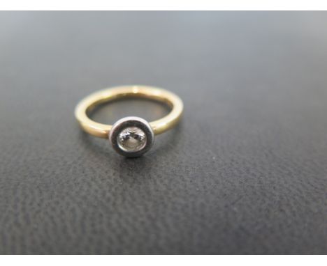 An 18ct gold diamond single-stone ring - The brilliant-cut diamond within a rub-over setting - Estimated diamond weight 0.25c