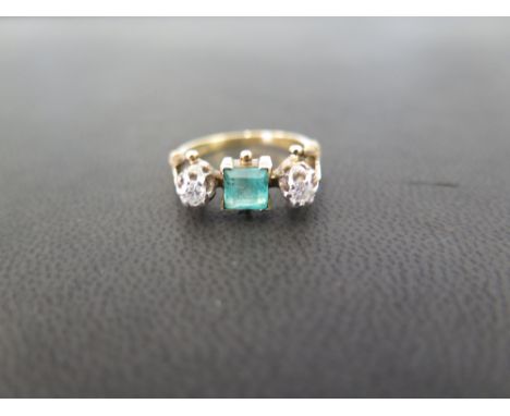 An emerald and diamond three-stone ring - The square-shape emerald to the brilliant-cut diamonds - Stamped 18ct - Ring size K