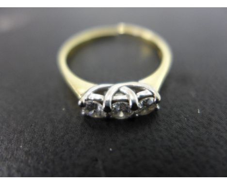 An 18ct gold diamond three-stone ring - The brilliant-cut diamonds to the plain band - Total diamond weight 0.50ct, stamped t