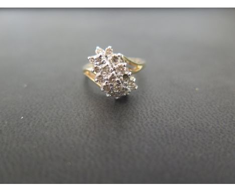 A brilliant-cut diamond cluster - With openwork asymmetric shoulders to the plain band - Stamped 14K - Ring size P - Weight a