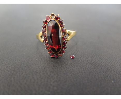 A garnet cluster ring - Stamped 9ct - Ring size W 1/2 - Weight approx 2.5gms
Condition Report: Fair - With surface scratches 