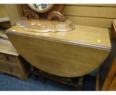 A vintage oak drop leaf gate legged dining table