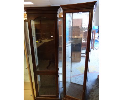 A vintage tall darkwood display cabinet together with a reproduction dark wood two section tall display cabinet