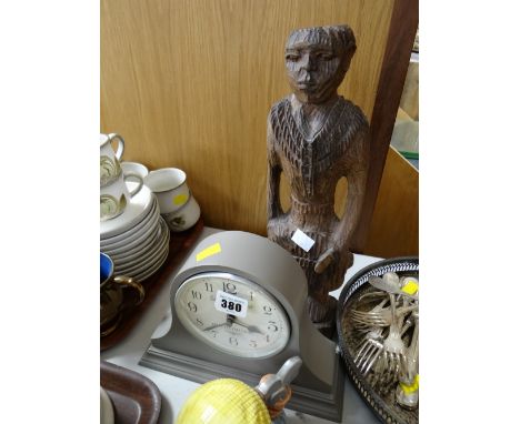 A modern London Clock Company dome top mantel clock together with a carved tribal figure