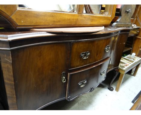 A vintage mahogany serpentine sideboard, two drawers flanked by two cupboards over cabriole supports