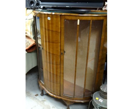 A vintage bow fronted walnut veneered two-door glass display cabinet