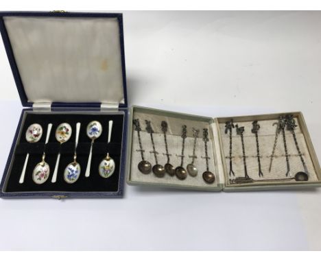 A cased set of silver and enamel spoons.