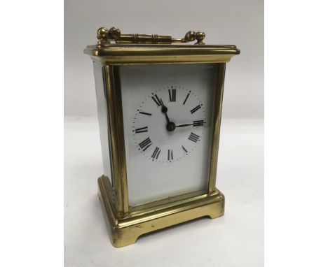 A brass cased carriage clock, approx 12cm. Comes with key.
