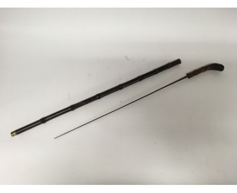 A Victorian bamboo sword stick with brass mounts and a curved handle.