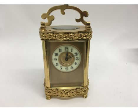 A French brass case carriage clock with visible escapement the dial with Arabic numerals