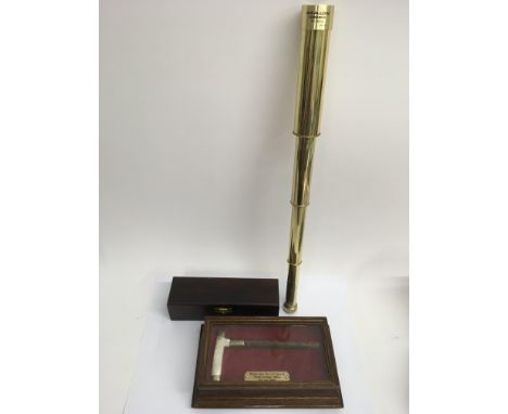 A brass Swallow Commander brass telescope in sodden case and a Mother of Pearl walking stick handle in glass case