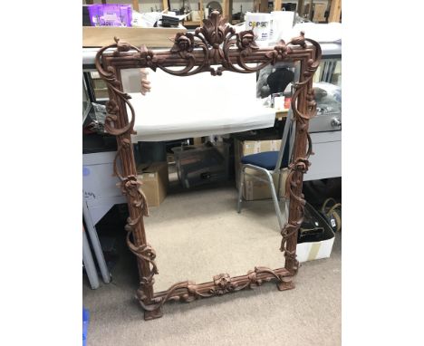 A modern carved wood wall mirror with bevelled edge. Size approx 72x113cm