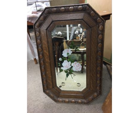 An oak framed mirror decorated with flowers. Approximately 83cm tall.