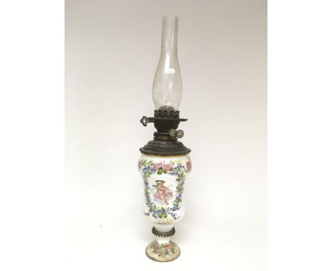 A ceramic painted oil lamp decorated with flowers and cherubs.