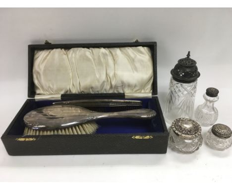 A cased silver backed brush and comb plus four silver topped glass pots.