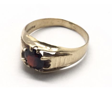 A 9carat gold ring insr with a solitaire red cut stone possible a ruby or garnet.