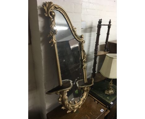 A gilt wall mirror with two applied self and raised flower heads 94 cm by 40 cm approx