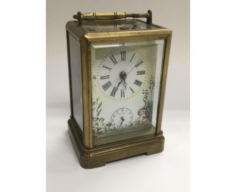 A brass carriage clock with painted clock face depicting cherubs and having a subsidiary dial, approx 15cm x 9cm x 7.5cm.