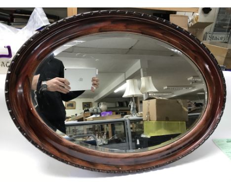 An oval bevelled edge mirror. Size approx 86x62cm
