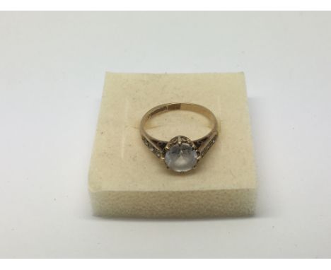 A gold ring set with a central white sapphire, approx 2.1g and approx size K-L.