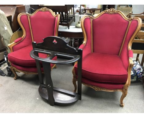 A pair of open arm chairs with red backing and an oak stick stand.