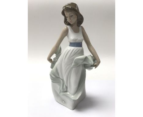 A porcelain Nao figure of a young girl.