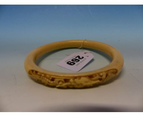 AN ANTIQUE JAPANESE IVORY BANGLE CARVED WITH TWO PANELS OF DRAGONS. 9.6 CM DIA.