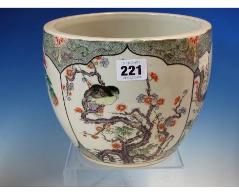 A CHINESE FAMILLE VERTE PLANTER PAINTED WITH FOUR PANELS OF FLOWERS AND BIRDS ON A BLACK STIPPLED GREEN GROUND.   Dia. 20.5cm