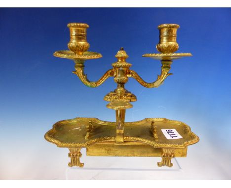 A 19th C. ORMOLU TWIN LIGHT SCRIBE'S CHAMBER STICK, THE TWO NOZZLES SUPPORTED BY TWO CARYATIDS ABOVE A WAISTED PEN TRAY ON FO