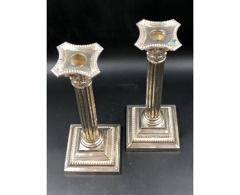 A PAIR OF HALLMARKED WEIGHTED SILVER CORINTHIAN COLUMN CANDLESTICKS ON SQUARE STEP BASES WITH REMOVABLE DRIP TRAYS,DATED 1909