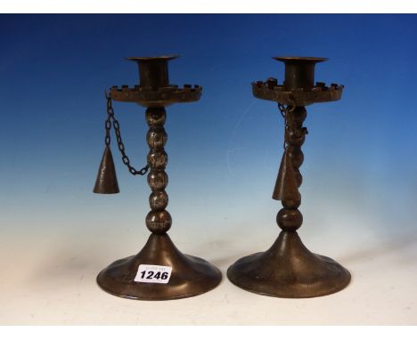 A PAIR OF GOBERG (HUGO BERGER) IRON CANDLESTICKS WITH SNUFFERS CHAINED TO THE CRENELLATED DRIP PANS, THE BOBBIN TURNED COLUMN