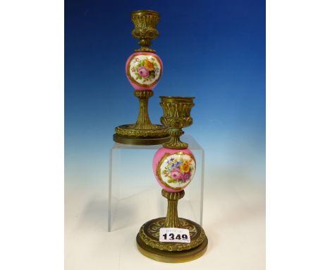 A PAIR OF BRONZE AND PORCELAIN CANDLESTICKS, THE ROSE POMPADOUR GROUND KNOPS EACH PAINTED WITH TWO FLORAL OVALS.   H 16cms.