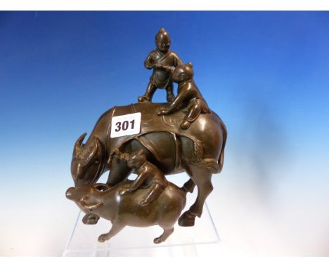 A CHINESE BRONZE GROUP OF THREE CHILDREN RIDING A WATER BUFFALO AND ITS CALF.   H 19cms.