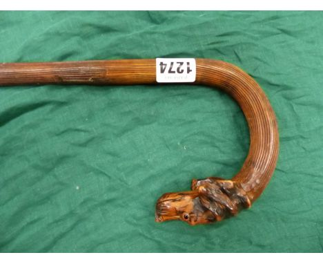 A VINTAGE WALKING STICK , THE HANDLE CARVED WITH DOGS HEAD AND WITH GLASS EYES . 93 CM LONG