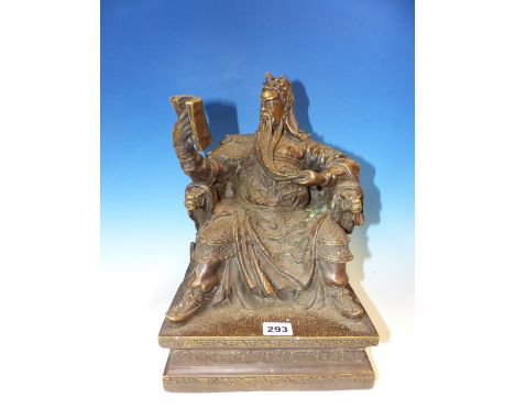 A CHINESE BRONZE FIGURE OF WENCHANG WANG ENTHRONED READING A BOOK IN HIS RIGHT HAND, HIS LEFT HAND HOLDING THE TIP OF HIS LON