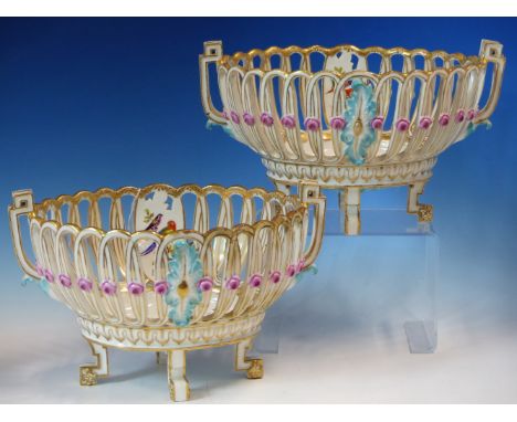 A PAIR OF MARCOLINI MEISSEN TWO HANDLED OVAL BASKETS, EACH PAINTED WITH EXOTIC BIRDS AND INSECTS AND ON FOUR GILT BRACKET FEE