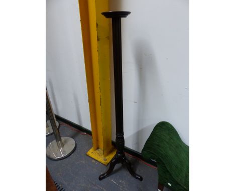 A MAHOGANY TORCHERE, THE REEDED COLUMN FLARING TO A SLENDER OVOID SHAPE CARVED WITH LEAVES ABOVE THE TRIPOD WITH LONG NOSE CL