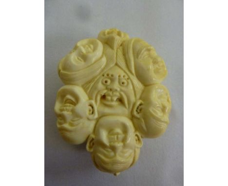 Oriental early 20th century ivory Netsuke, carved with a variety of faces with various expressions, signed to the back