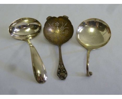 A silver tea strainer, a Dutch white metal ladle and a Scottish silver ladle