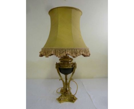 A French 19th century style neo-classical brass table lamp the central vase supported by mask mounted scrolling supports on a