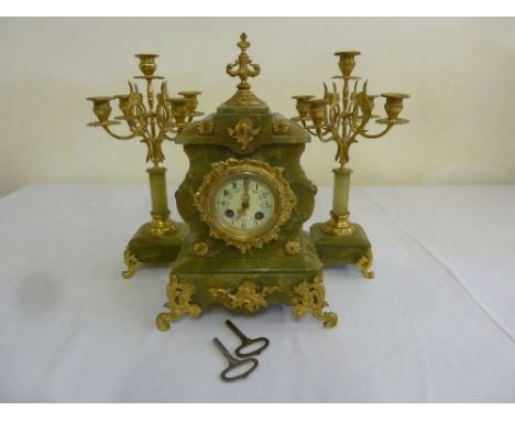 A 19th century onyx and gilt metal mantle clock with two flanking five light candlelabra