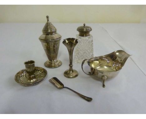 A quantity of silver to include an Art Deco sugar sifter, a sauce boat and a chamber stick