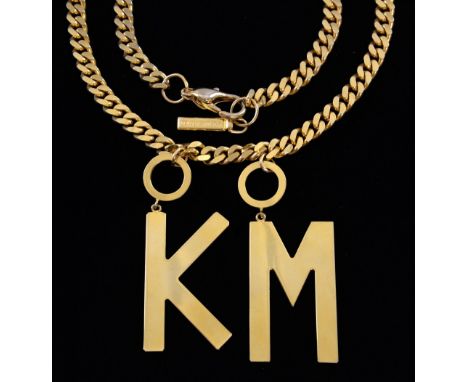 Kylie Minogue, A 'gold plated' flat curb link chain necklace with suspended twin pendants of initials K & M with suspended ta