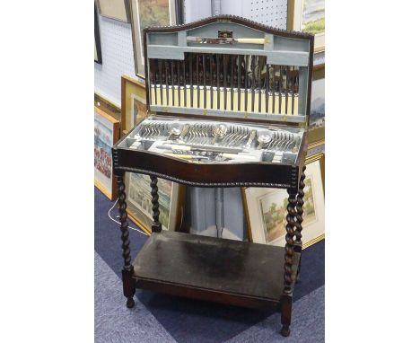 A CIRCA 1920's OAK FREE STANDING SERPENTINE FRONT CUTLERY CANTEEN, raised on spiral supports and containing a VINERS 'OLD ENG