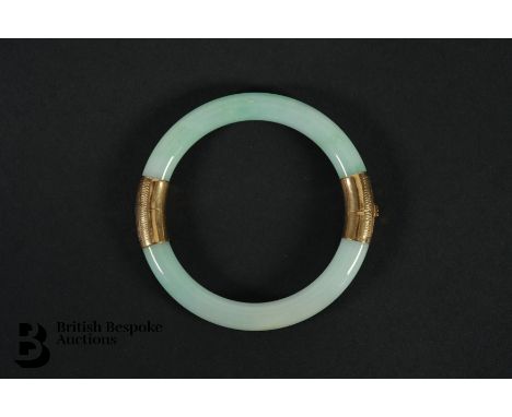 An 18ct yellow gold and jade bangle. The bangle internal diameter measures 52mm, the jade width measures 9mm, approx 32.6 gms